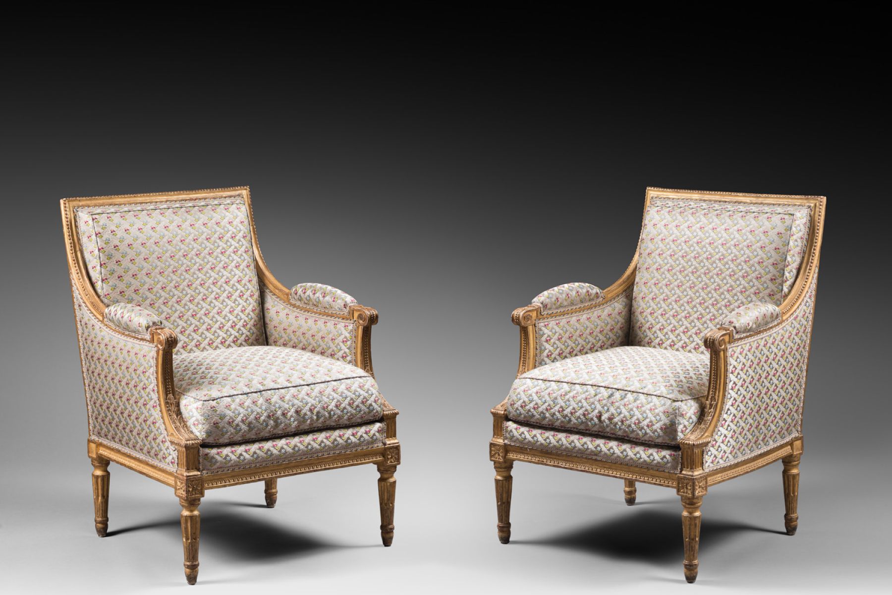 A pair of Louis XVI gilded wood bergeres